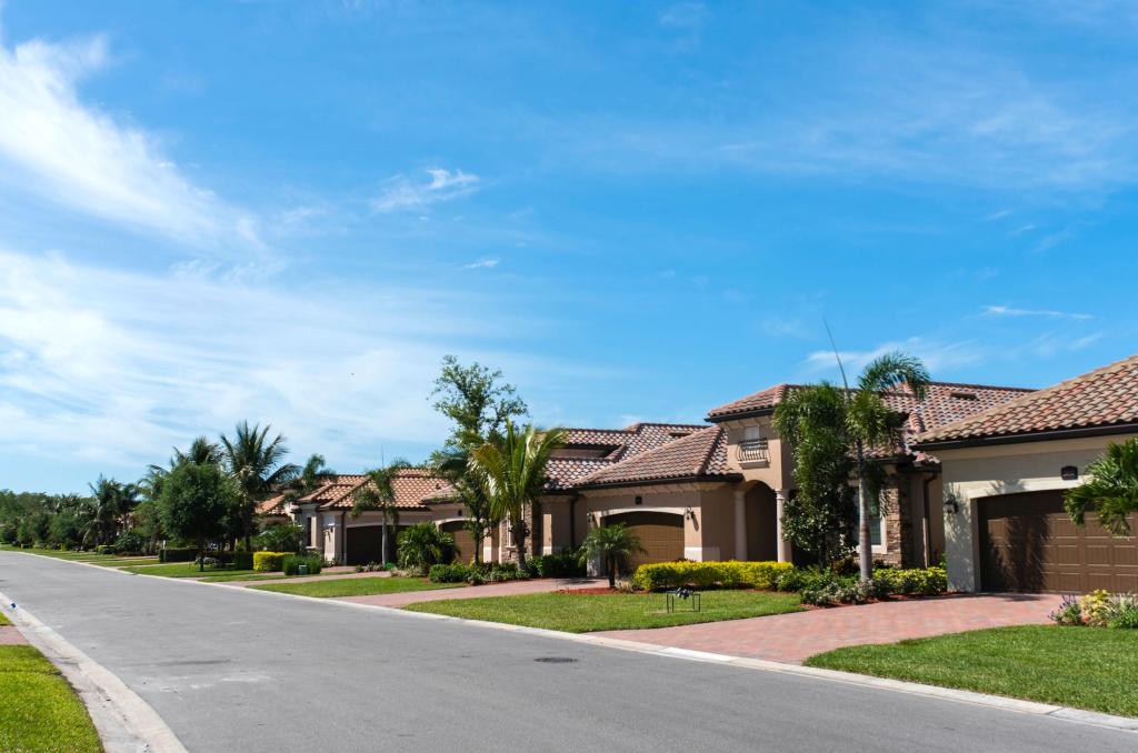 Modern single-family homes in a gated South Florida community with palm trees, landscaped streets, and luxury real estate for sale in Florida.